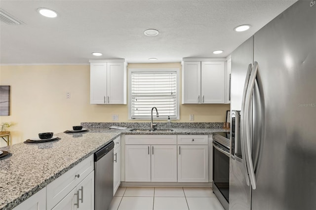 7401 Islander Ln, Hudson, FL 34667 - kitchen with stainless steel appliances, white cabinetry, light stone countertops, recessed lighting, and light tile patterned flooring