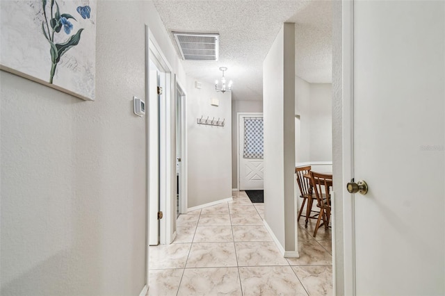 4108 Woodtrail Blvd, New Port Richey, FL 34653 - hallway featuring a textured ceiling and a chandelier