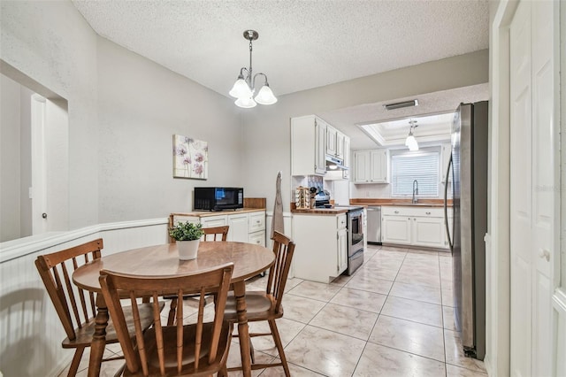 4108 Woodtrail Blvd, New Port Richey, FL 34653 - dining room featuring a tray ceiling, a textured ceiling, a chandelier, and light tile patterned flooring
