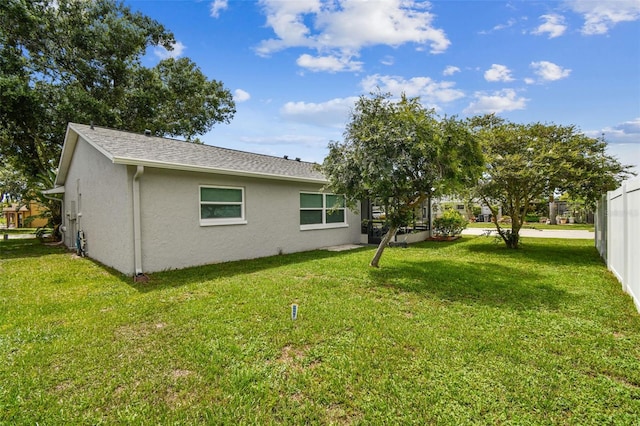 4108 Woodtrail Blvd, New Port Richey, FL 34653 - back of property featuring stucco siding and a yard