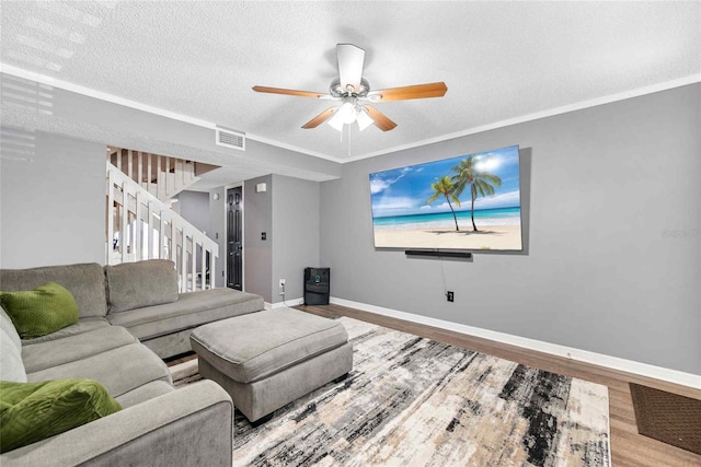 3350 Fox Hunt Dr, Palm Harbor, FL 34683 - living room featuring wood finished floors, a ceiling fan, stairway, and a textured ceiling
