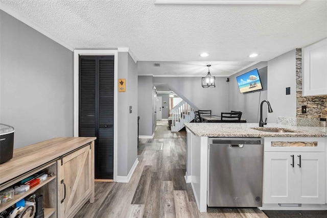 3350 Fox Hunt Dr, Palm Harbor, FL 34683 - kitchen with stainless steel dishwasher, wood finished floors, white cabinetry, a textured ceiling, and a chandelier