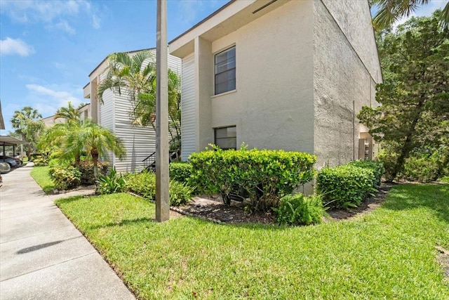 7811 Niagara Ave Unit 2125, Tampa, FL 33617 - view of property exterior with stucco siding and a lawn