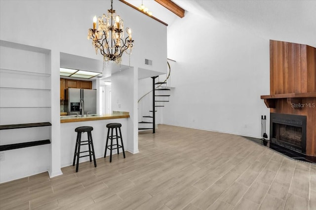 7811 Niagara Ave Unit 2125, Tampa, FL 33617 - living area with stairway, beam ceiling, high vaulted ceiling, a large fireplace, and a chandelier