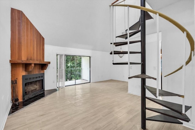 7811 Niagara Ave Unit 2125, Tampa, FL 33617 - unfurnished living room with stairway, a tiled fireplace, and light wood-type flooring
