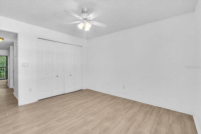 7811 Niagara Ave Unit 2125, Tampa, FL 33617 - unfurnished bedroom featuring light wood finished floors, a closet, a textured ceiling, and a ceiling fan