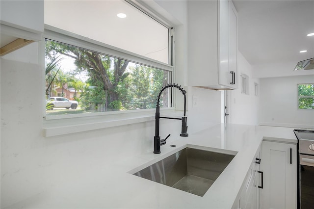 6108 Oak Ridge Ave, New Port Richey, FL 34653 - kitchen with stainless steel electric range, white cabinetry, light countertops, and recessed lighting