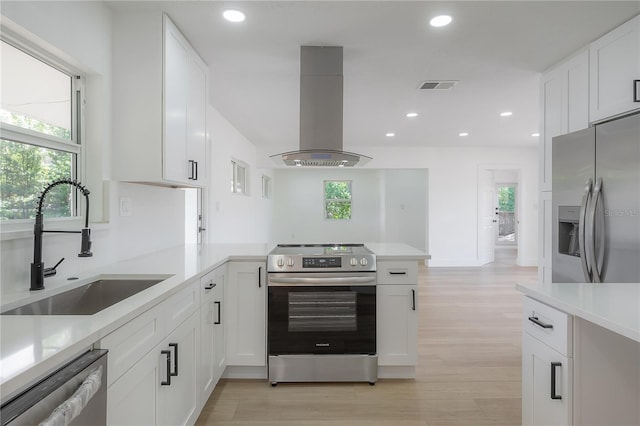 6108 Oak Ridge Ave, New Port Richey, FL 34653 - kitchen featuring island exhaust hood, appliances with stainless steel finishes, light countertops, a peninsula, and recessed lighting