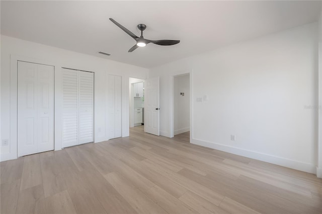 6108 Oak Ridge Ave, New Port Richey, FL 34653 - unfurnished bedroom with light wood finished floors, a ceiling fan, and multiple closets