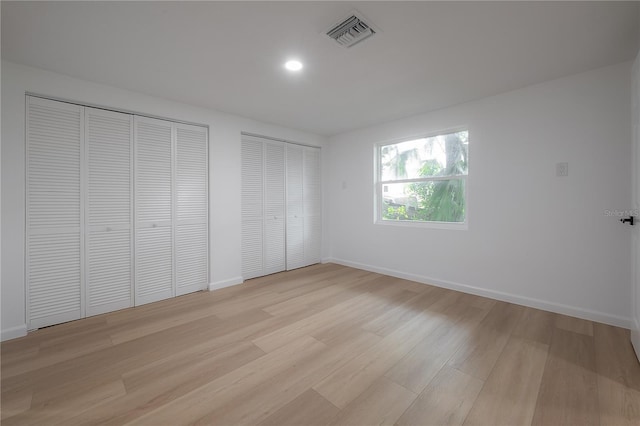 6108 Oak Ridge Ave, New Port Richey, FL 34653 - unfurnished bedroom featuring multiple closets, light wood-style flooring, and recessed lighting