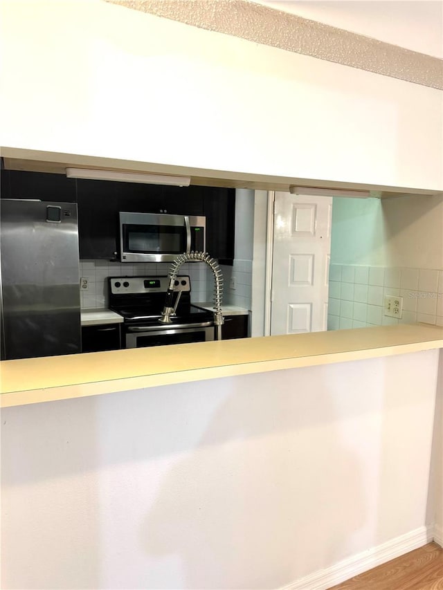 4207 Winding Moss Trl Unit 201, Tampa, FL 33613 - kitchen with appliances with stainless steel finishes, backsplash, wood finished floors, and light countertops