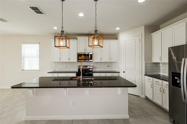 13408 Nimble Minke Unit 155E, Riverview, FL 33579 - kitchen with appliances with stainless steel finishes, recessed lighting, a kitchen island with sink, a textured ceiling, and backsplash
