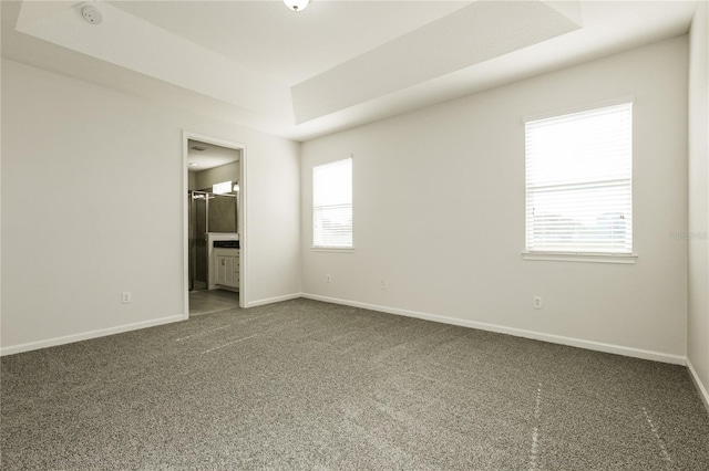 13408 Nimble Minke Unit 155E, Riverview, FL 33579 - unfurnished bedroom featuring a raised ceiling, dark colored carpet, and ensuite bathroom