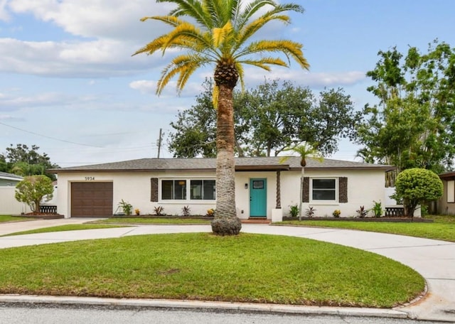 5934 51st Ave N, Kenneth City, FL 33709 - ranch-style home featuring curved driveway, a front yard, a garage, and stucco siding