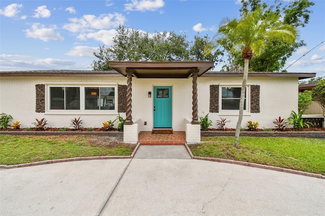 5934 51st Ave N, Kenneth City, FL 33709 - ranch-style house featuring brick siding and a front lawn