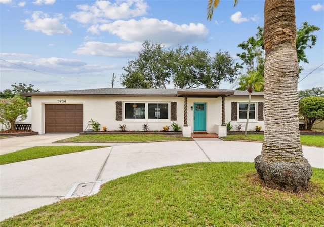 5934 51st Ave N, Kenneth City, FL 33709 - single story home with curved driveway, an attached garage, a front yard, and brick siding