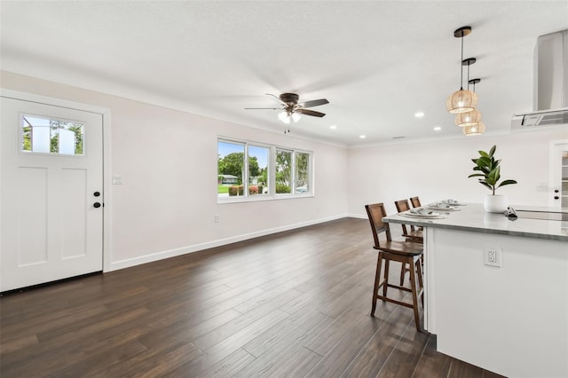 5934 51st Ave N, Kenneth City, FL 33709 - kitchen with ceiling fan, a kitchen bar, dark wood-style flooring, hanging light fixtures, and recessed lighting