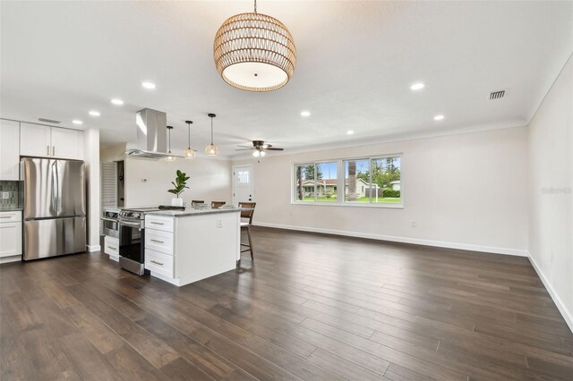 5934 51st Ave N, Kenneth City, FL 33709 - kitchen featuring stainless steel appliances, wall chimney exhaust hood, a breakfast bar area, recessed lighting, and open floor plan
