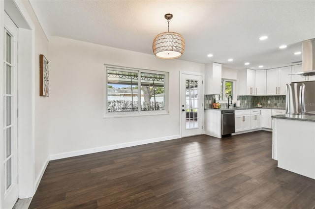 5934 51st Ave N, Kenneth City, FL 33709 - kitchen with appliances with stainless steel finishes, decorative backsplash, dark wood finished floors, white cabinetry, and dark countertops