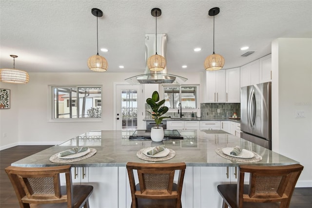 5934 51st Ave N, Kenneth City, FL 33709 - kitchen with freestanding refrigerator, white cabinetry, stovetop, decorative backsplash, and recessed lighting
