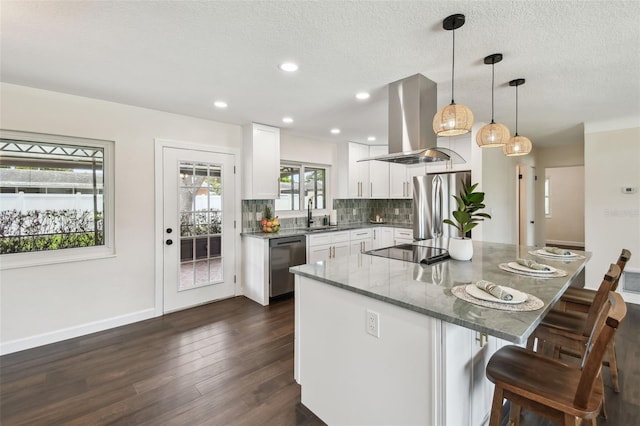 5934 51st Ave N, Kenneth City, FL 33709 - kitchen featuring island exhaust hood, stainless steel appliances, a breakfast bar, white cabinetry, and a center island