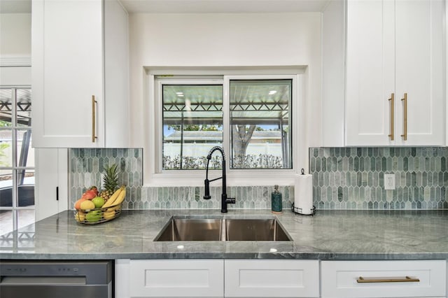 5934 51st Ave N, Kenneth City, FL 33709 - kitchen with stainless steel dishwasher, tasteful backsplash, white cabinetry, and dark stone counters