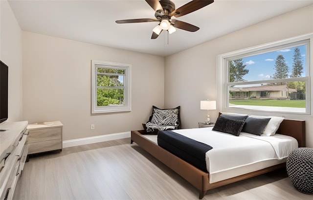 5934 51st Ave N, Kenneth City, FL 33709 - bedroom with light wood finished floors and a ceiling fan
