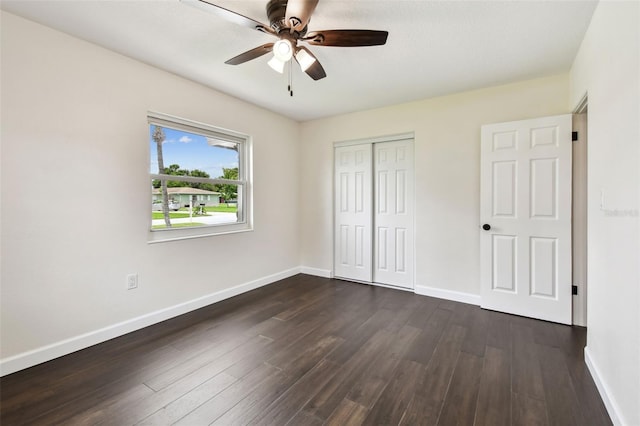 5934 51st Ave N, Kenneth City, FL 33709 - unfurnished bedroom with dark wood-style flooring, a closet, and ceiling fan