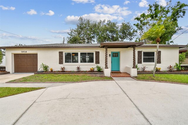 5934 51st Ave N, Kenneth City, FL 33709 - ranch-style house with a garage, driveway, brick siding, and a front yard