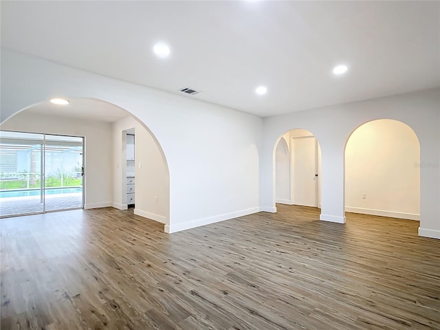 20352 Astoria Ave, Port Charlotte, FL 33952 - spare room with wood finished floors, recessed lighting, and arched walkways