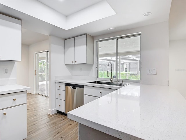 20352 Astoria Ave, Port Charlotte, FL 33952 - kitchen with dishwasher, light countertops, white cabinetry, light wood-style floors, and a peninsula