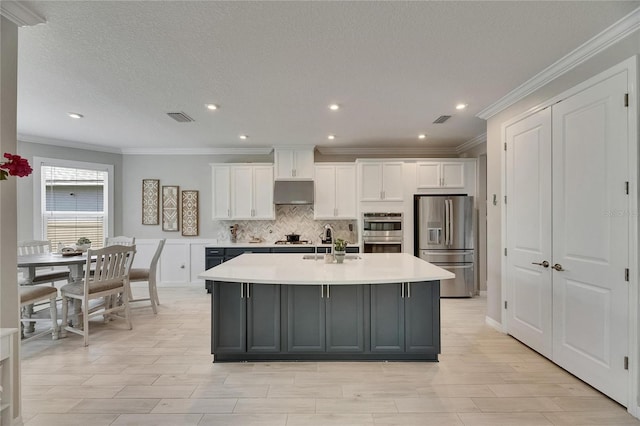 10399 Boyette Brook St, Riverview, FL 33569 - kitchen with appliances with stainless steel finishes, white cabinets, crown molding, light countertops, and under cabinet range hood