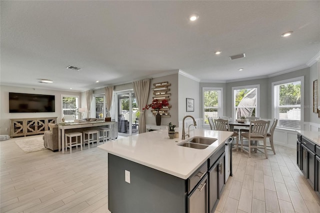 10399 Boyette Brook St, Riverview, FL 33569 - kitchen with ornamental molding, a center island with sink, open floor plan, light countertops, and light wood-style floors