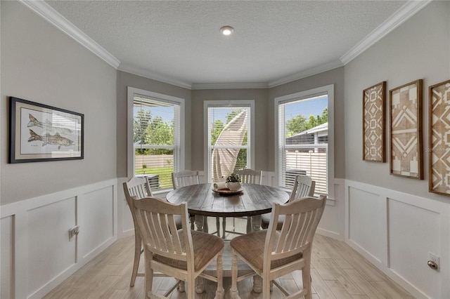 10399 Boyette Brook St, Riverview, FL 33569 - dining room featuring light wood-style flooring, a decorative wall, a textured ceiling, and wainscoting