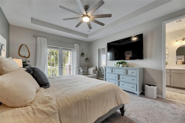 10399 Boyette Brook St, Riverview, FL 33569 - bedroom with access to exterior, light carpet, connected bathroom, a tray ceiling, and a ceiling fan