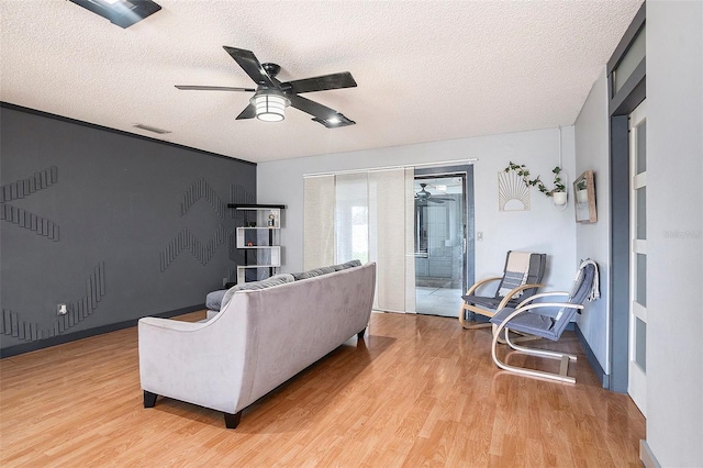 15906 Country Farm Pl, Tampa, FL 33624 - living area with ceiling fan, light wood finished floors, and a textured ceiling