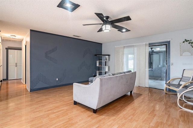 15906 Country Farm Pl, Tampa, FL 33624 - living room featuring a ceiling fan, light wood-style floors, and a textured ceiling