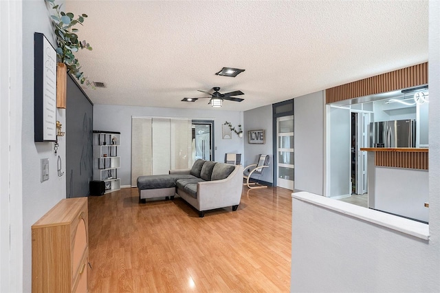 15906 Country Farm Pl, Tampa, FL 33624 - living area with a textured ceiling, light wood-style flooring, and a ceiling fan