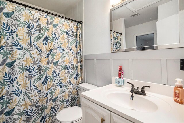 15906 Country Farm Pl, Tampa, FL 33624 - bathroom with a decorative wall, vanity, a shower with shower curtain, and a wainscoted wall
