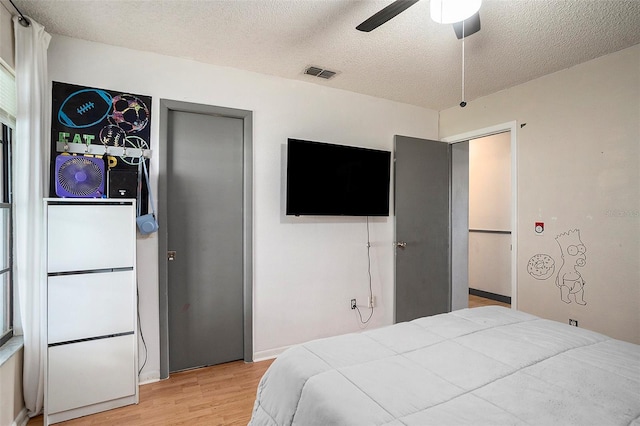 15906 Country Farm Pl, Tampa, FL 33624 - bedroom featuring light wood-style flooring, a textured ceiling, and a ceiling fan