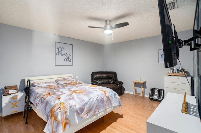 15906 Country Farm Pl, Tampa, FL 33624 - bedroom with light wood-style flooring, a textured ceiling, and a ceiling fan