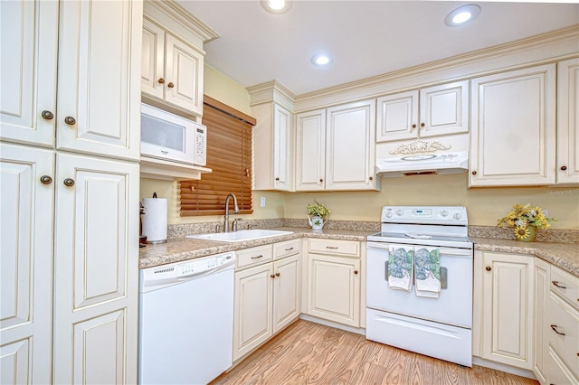 340 Pinellas Bayway S Unit 304, Saint Petersburg, FL 33715 - kitchen with white appliances, under cabinet range hood, light countertops, light wood-style floors, and recessed lighting