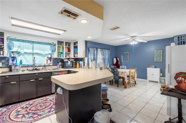 7018 Arbor View Ln, New Port Richey, FL 34653 - kitchen with freestanding refrigerator, a peninsula, light countertops, black microwave, and light tile patterned floors