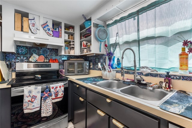 7018 Arbor View Ln, New Port Richey, FL 34653 - kitchen featuring stainless steel electric stove, under cabinet range hood, decorative backsplash, light countertops, and dark cabinets