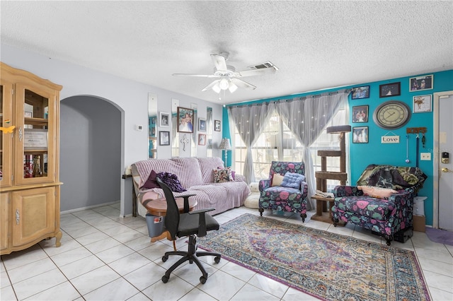 7018 Arbor View Ln, New Port Richey, FL 34653 - living room with arched walkways, ceiling fan, light tile patterned floors, and a textured ceiling