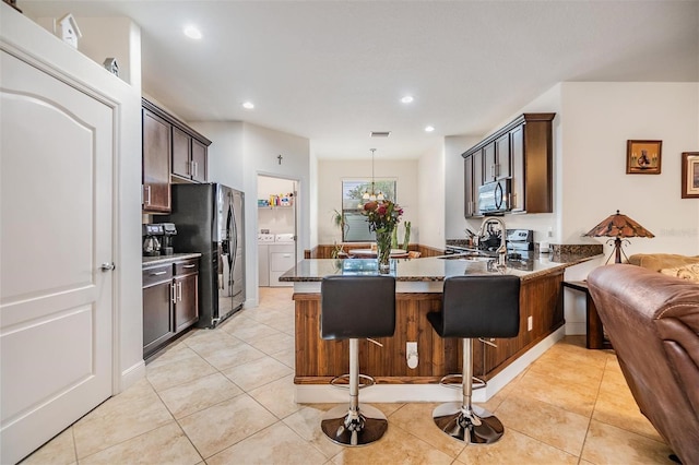 12251 Duckett Ct, Spring Hill, FL 34610 - kitchen featuring fridge with ice dispenser, dark stone countertops, a peninsula, washer and dryer, and range