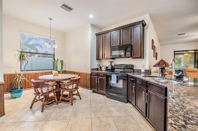 12251 Duckett Ct, Spring Hill, FL 34610 - kitchen featuring black appliances, wainscoting, dark stone countertops, dark brown cabinetry, and wood walls