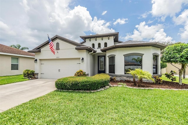 12251 Duckett Ct, Spring Hill, FL 34610 - mediterranean / spanish home featuring stucco siding, an attached garage, driveway, and a front yard