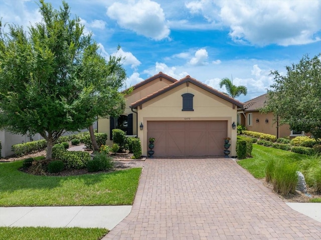 10450 Highland Park Pl, Palmetto, FL 34221 - ranch-style home featuring an attached garage, stucco siding, decorative driveway, and a front lawn
