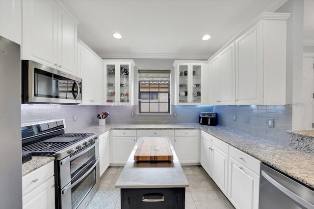 10450 Highland Park Pl, Palmetto, FL 34221 - kitchen with stainless steel appliances, light tile patterned floors, white cabinetry, and recessed lighting
